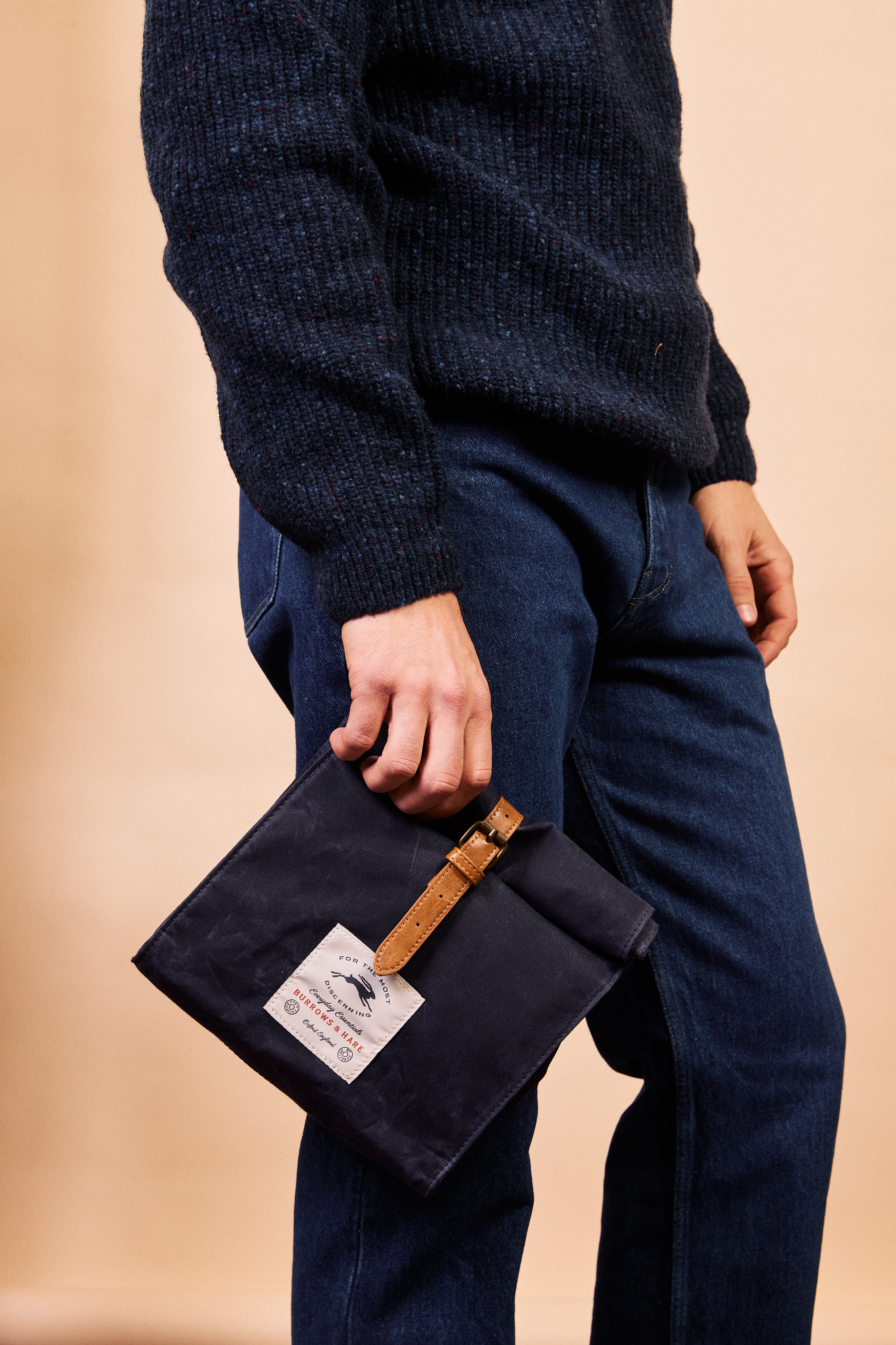 Burrows & Hare navy thermal lunch bag held by the leather strap