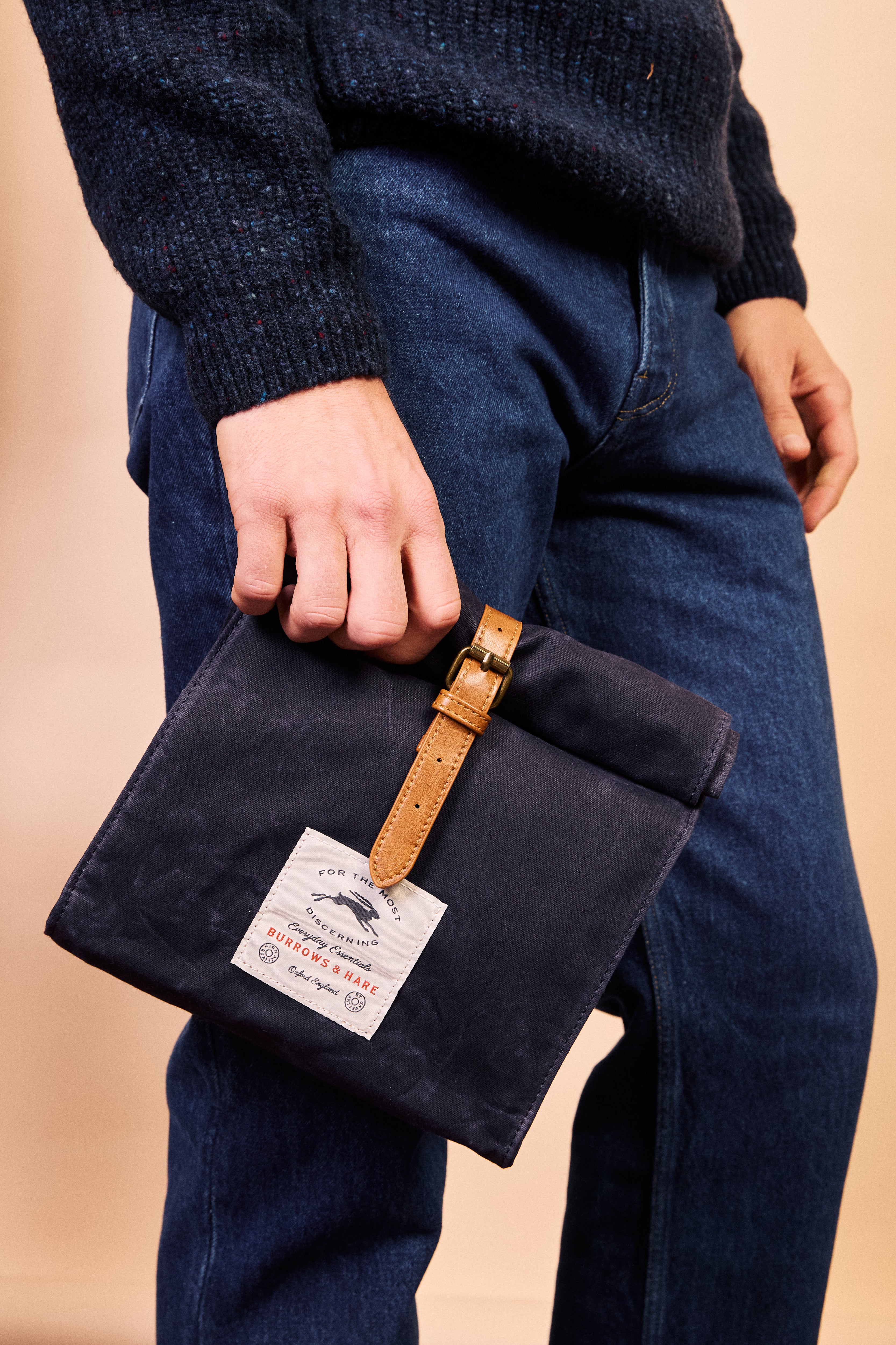Close-up of the leather strap and accents on the navy thermal lunch bag